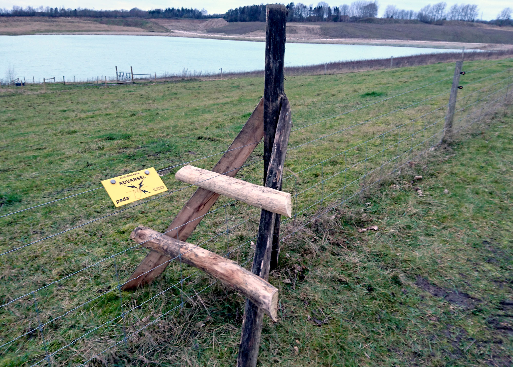 Eine Holztreppe führt von einer Seite des Zauns zur anderen.