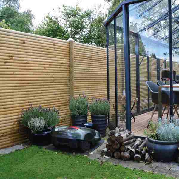 Der schöne Lund Gartenzaun in einem Garten mit Pflanzen