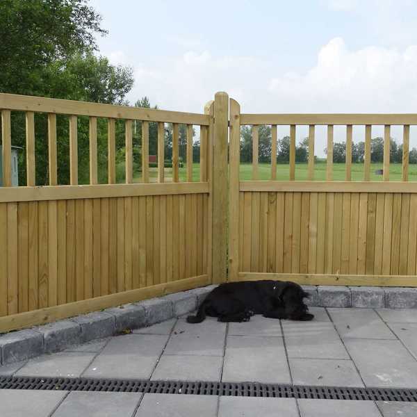 Ein Hund macht ein Nickerchen vor einem „Country Garden“-Zaun