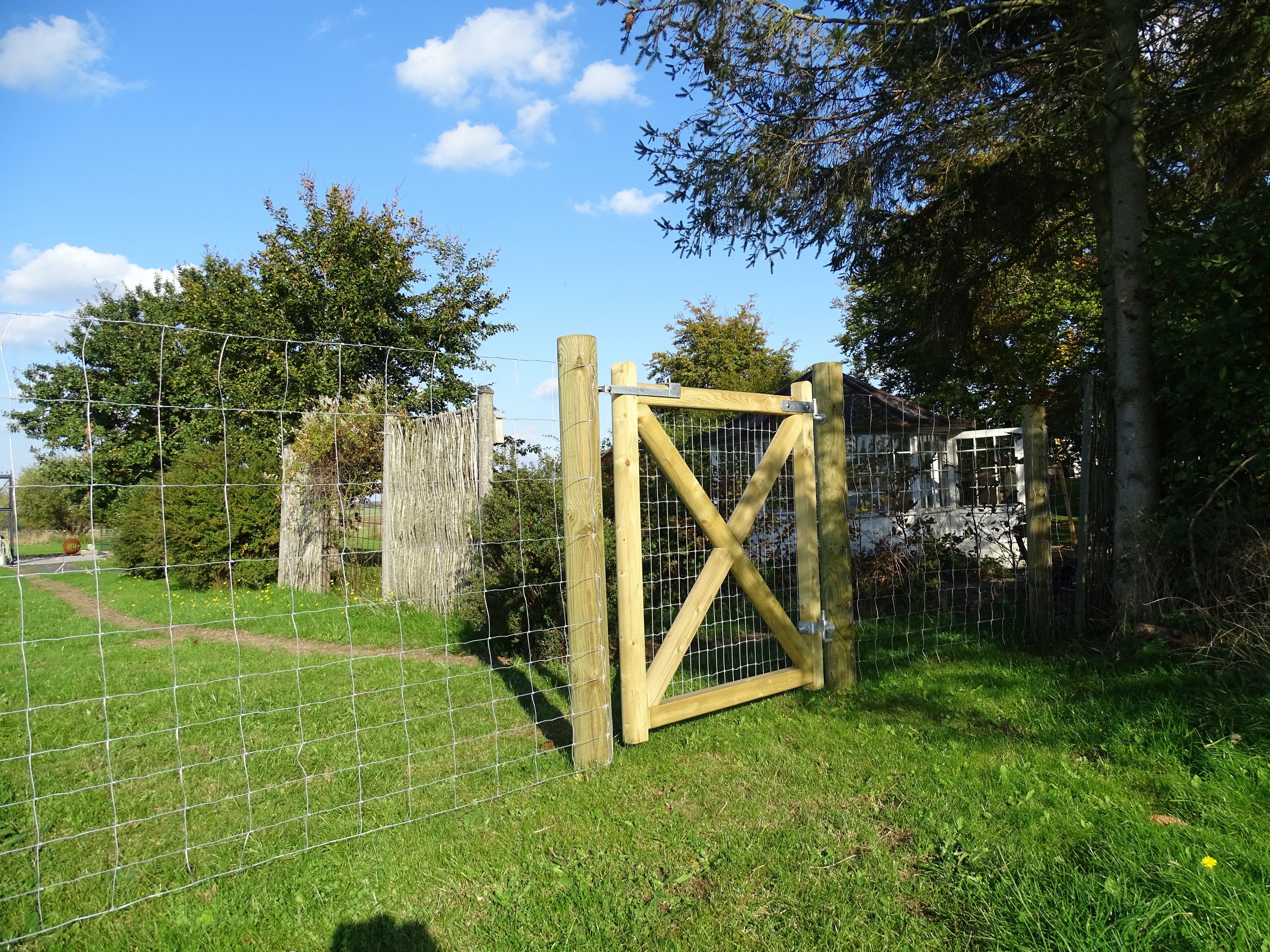 Ein geschlossenes 'Country Estate'-Tor wird in einem Garten montiert
