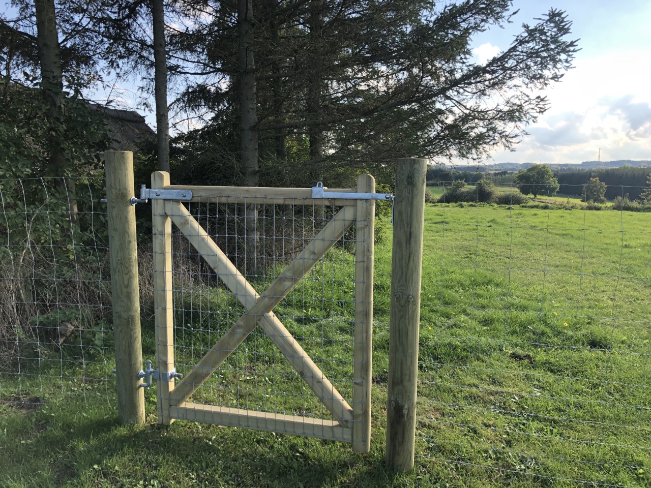 In Verlängerung eines Maschendrahtzauns wird ein Country Estate Tor installiert