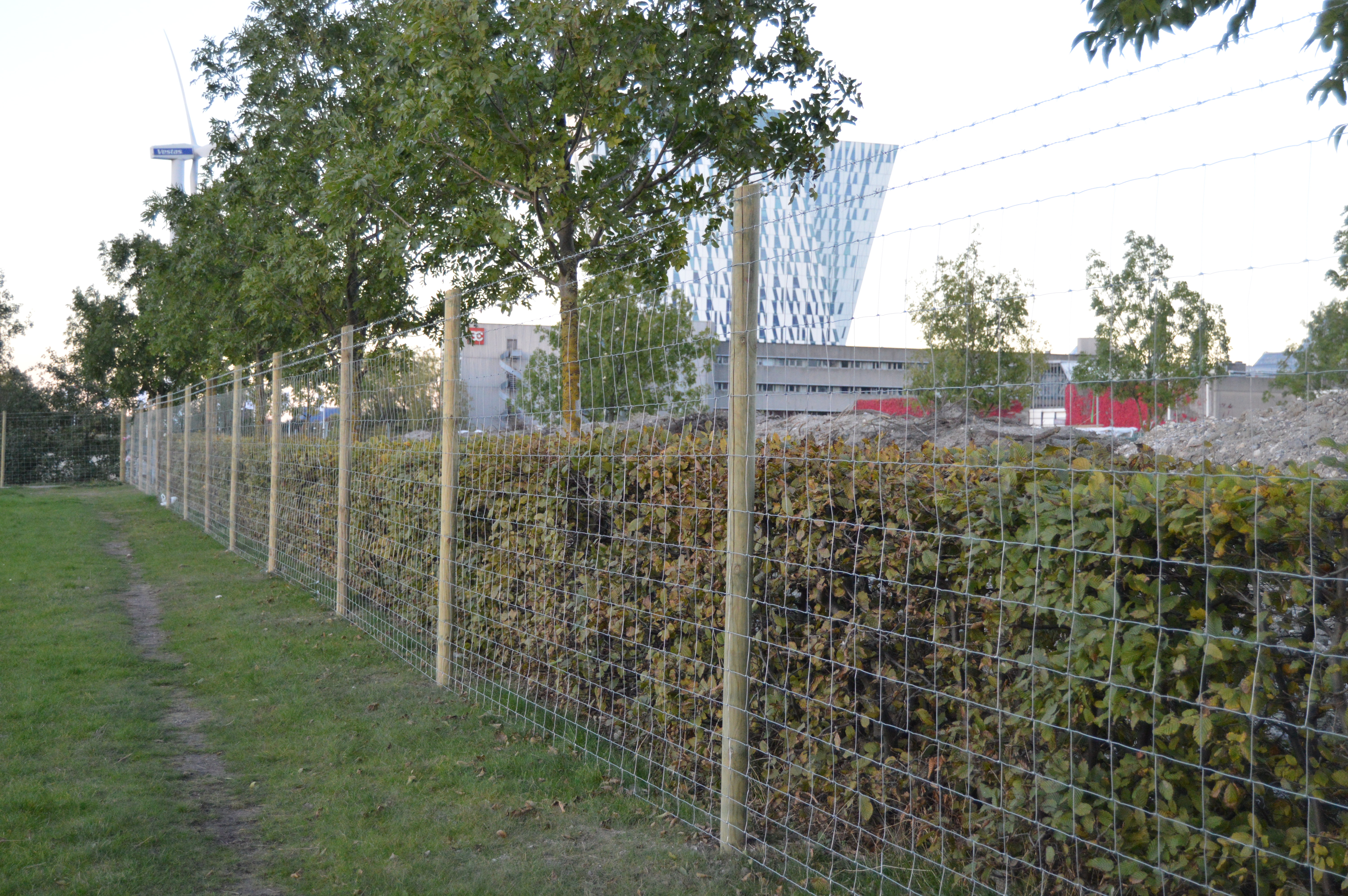 Auf einer Baustelle wird ein Baustellenzaun aufgestellt, um die Sicherheit auf der Baustelle zu erhöhen