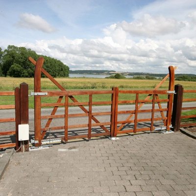 Ein Country Ranger- Tor ist neben einer Straße angebracht. Im Hintergrund sind ein Feld und ein See zu sehen