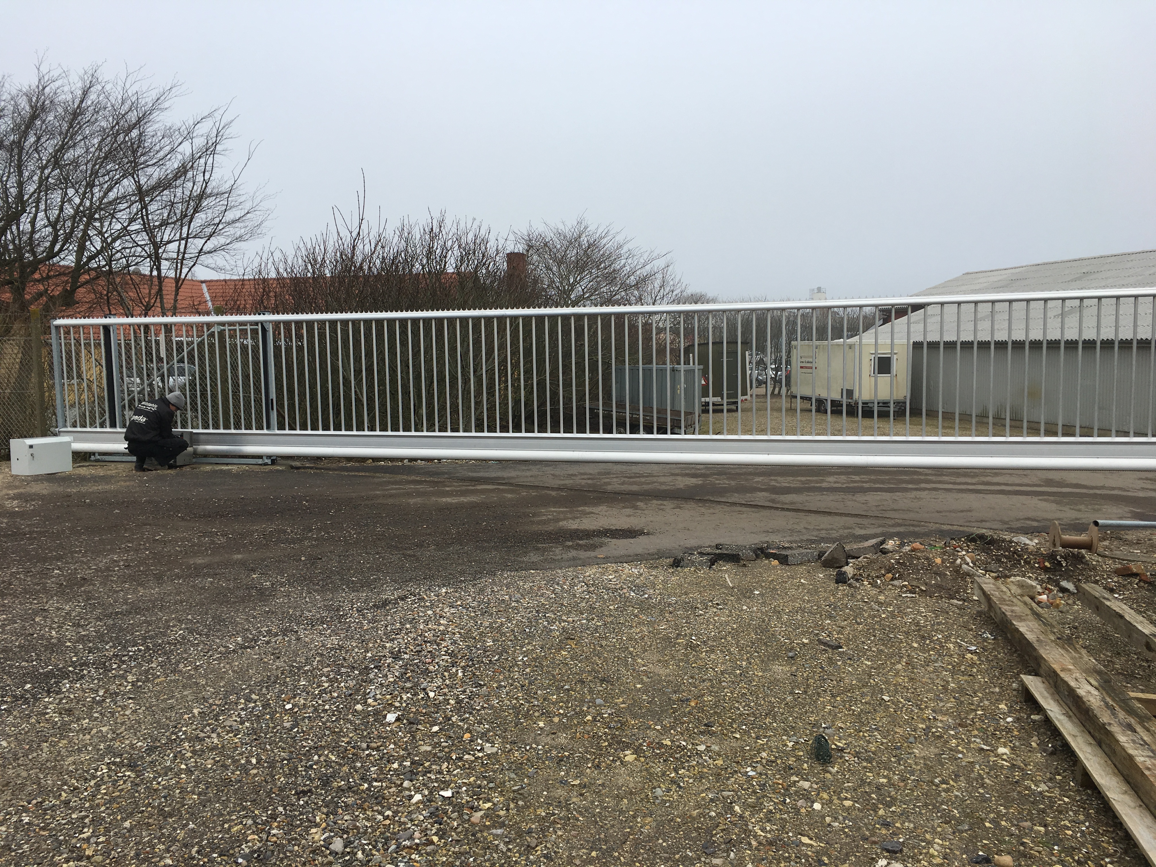 Ein Installateur baut ein automatisches Schiebetore ein