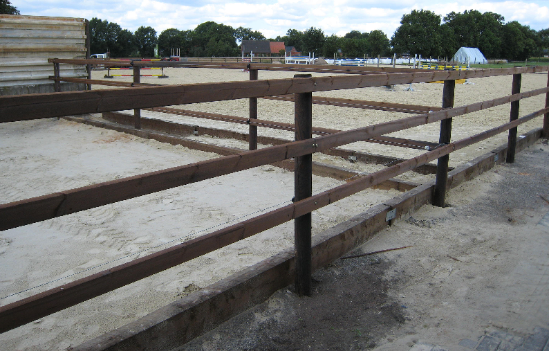 Paddock mit drei Latten. Im Hintergrund ist eine Sprungbahn zu sehen.