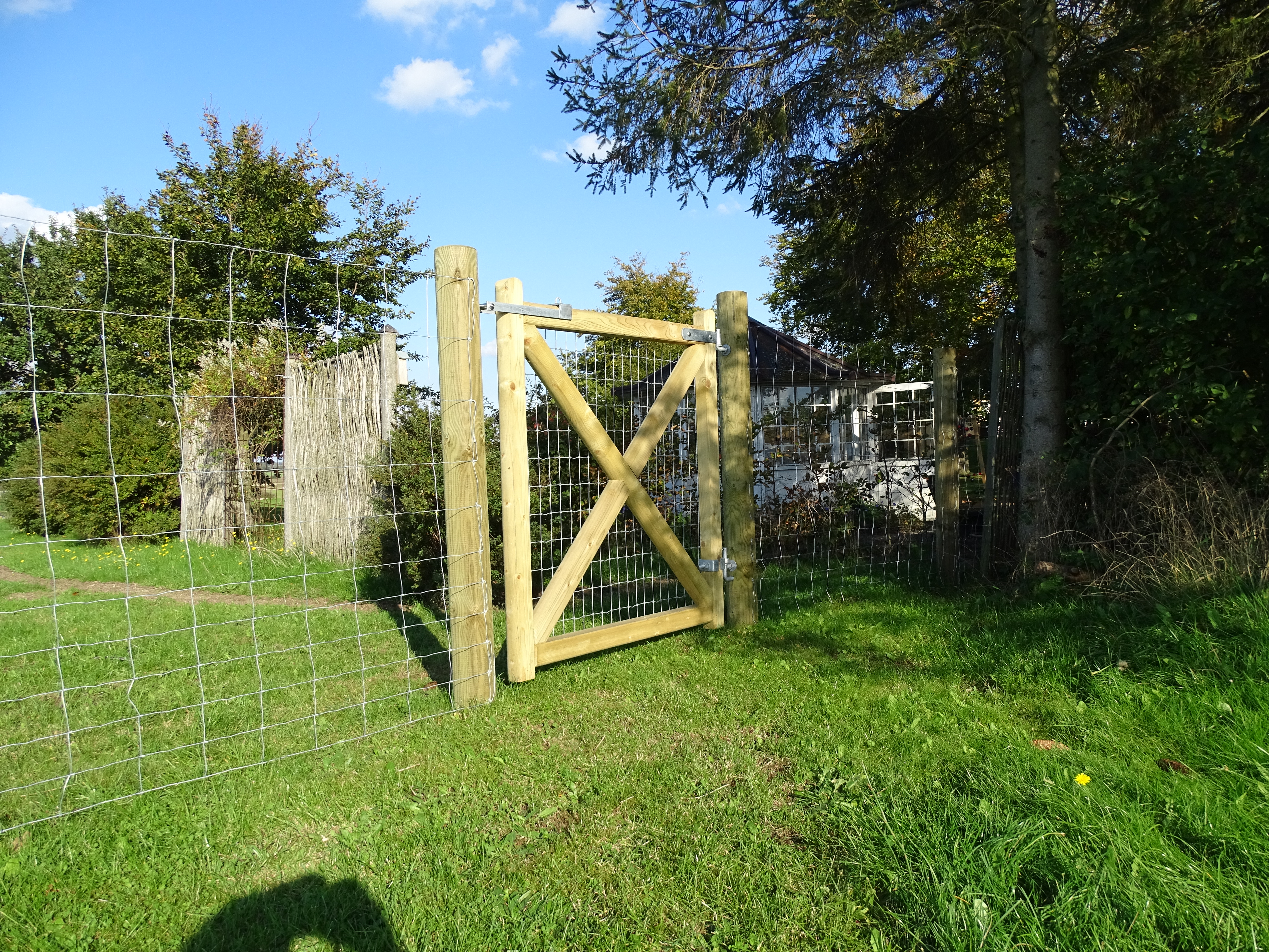 In einem Garten ist ein Country Estate Tor montiert. Im Hintergrund kann man das Haus sehen.