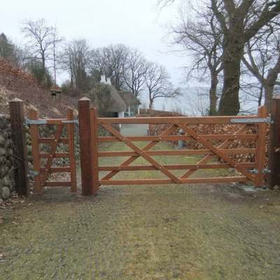In einer Einfahrt wird ein „Country House“ Hartholztor installiert