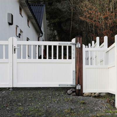 In der Mitte einer Zaunlinie steht ein Country Garden-Tor, das wie der Zaun weiß gestrichen ist.