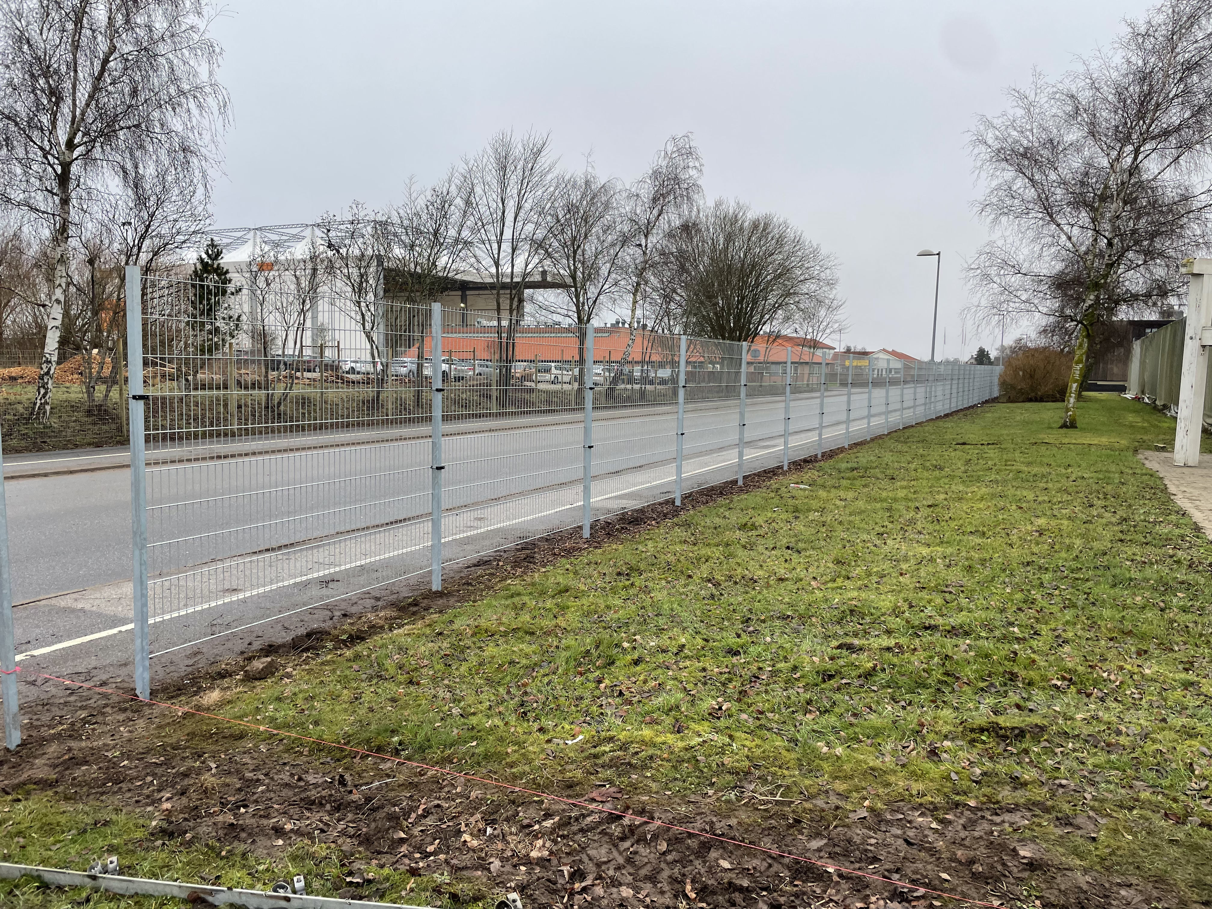 Ein Unternehmen hat einen grauen Doppelstabmattenzaun an einer Straße angebracht, um sie vor Diebstahl und Vandalismus zu schützen.