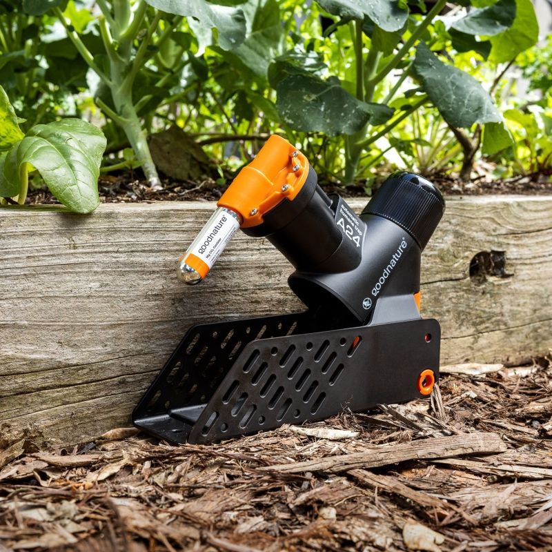 Goodnature Ratten- und Mausefalle in einem Garten an einer Holzbegrenzung installiert.