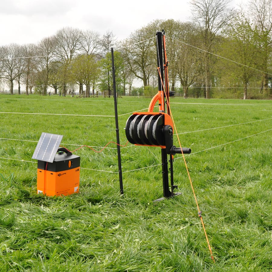 Ein SmartFence, der ausgerollt wird und mit einem Weidezaungerät verbunden ist
