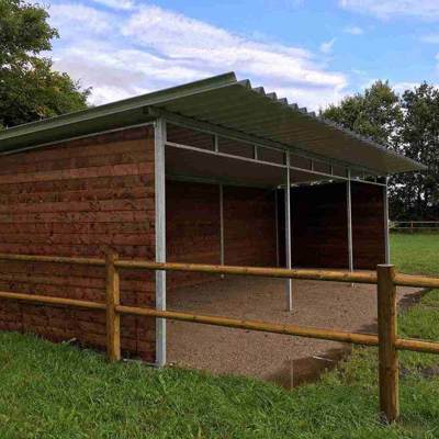 Ein Weidehütt steht inmitten eines Tiergeheges.