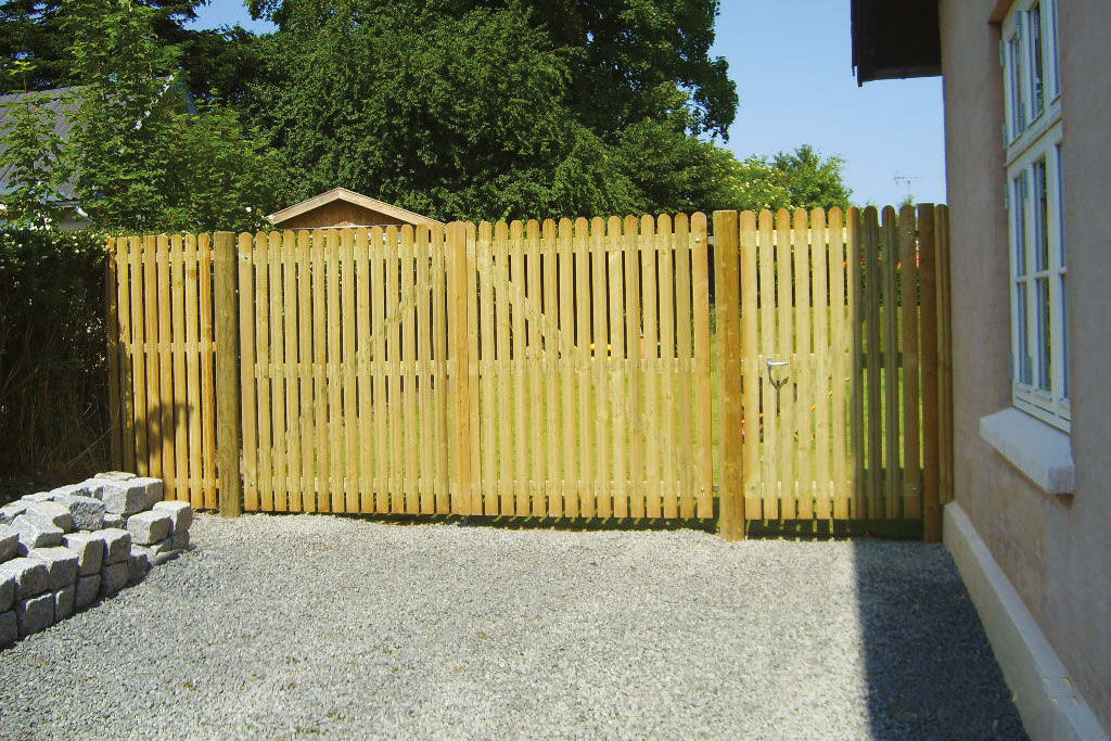 Ein hohes Doppeltor und eine Tür mit Fußgängern bilden den Eingang zu einem Garten.