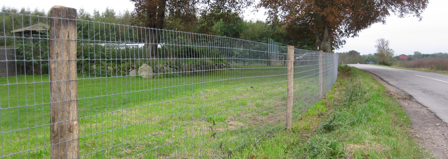 Ein Garten ist mit Multinet auf Holzpfählen eingezäunt