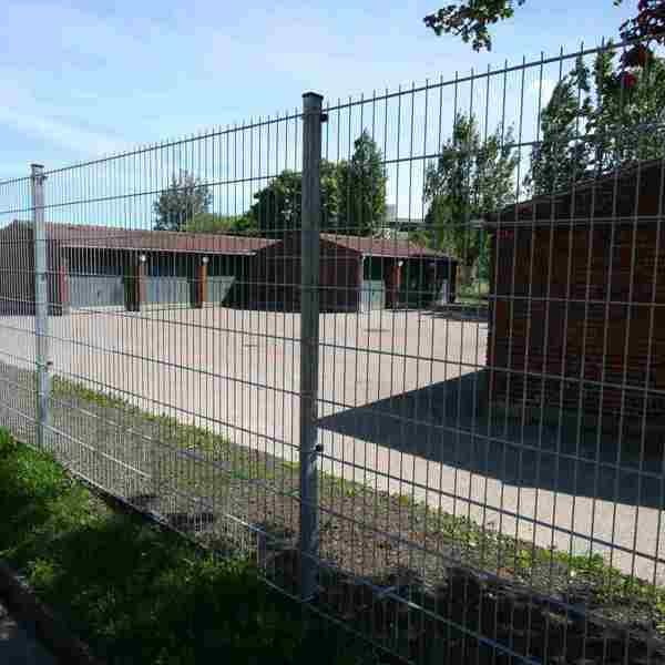 Die Garage wird durch einen Doppelstabmattenzaun geschützt.