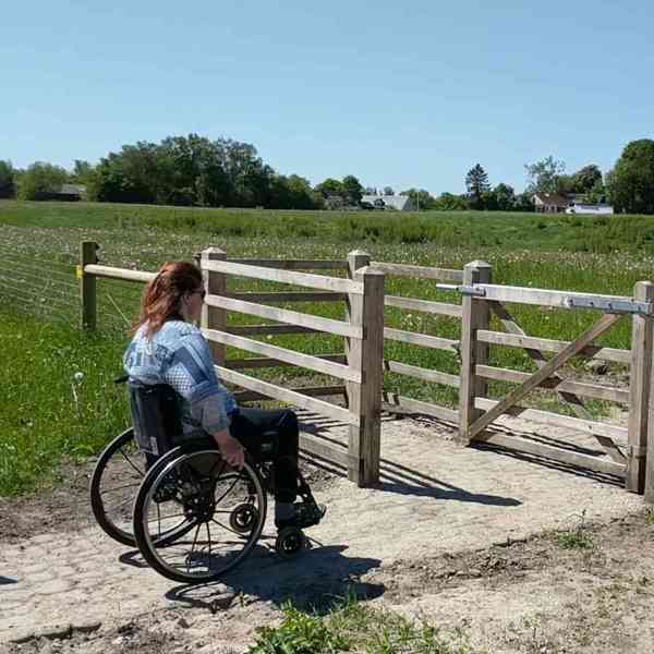 Eine Dame im Rollstuhl benutzt ein HandyGate